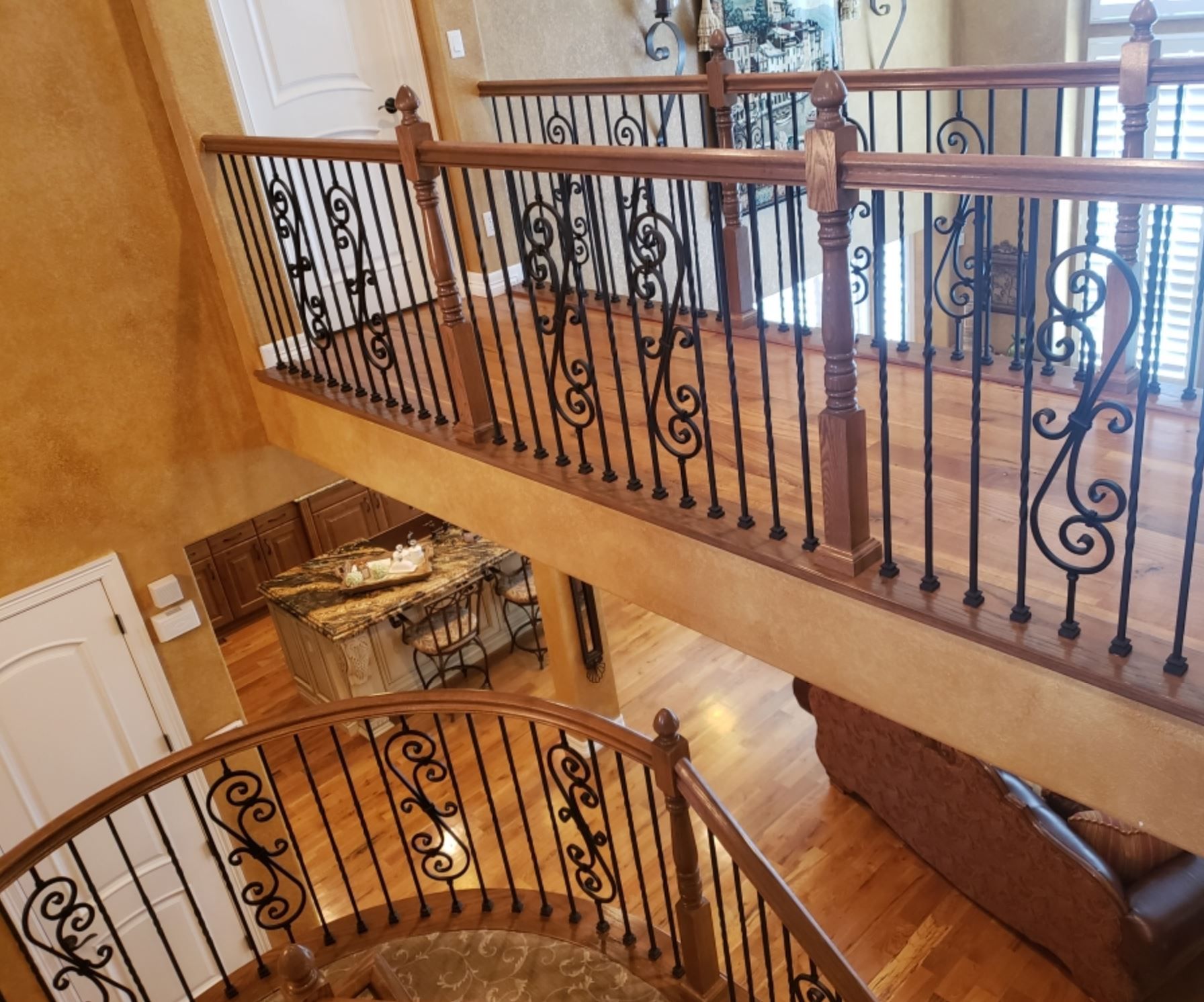 A spiral staircase with a wrought iron railing in a house.