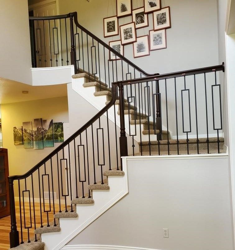 A staircase in a house with pictures on the wall above it