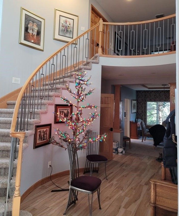 A staircase with a christmas tree in front of it