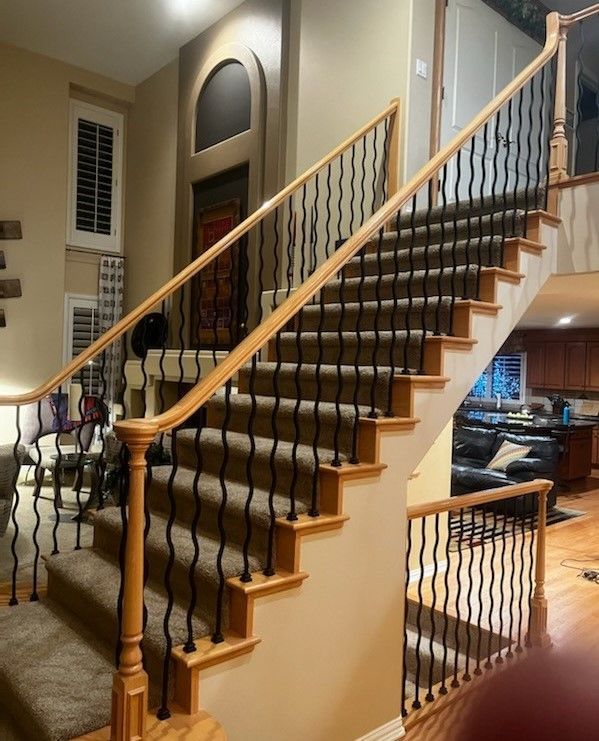 A wooden staircase with a metal railing in a living room