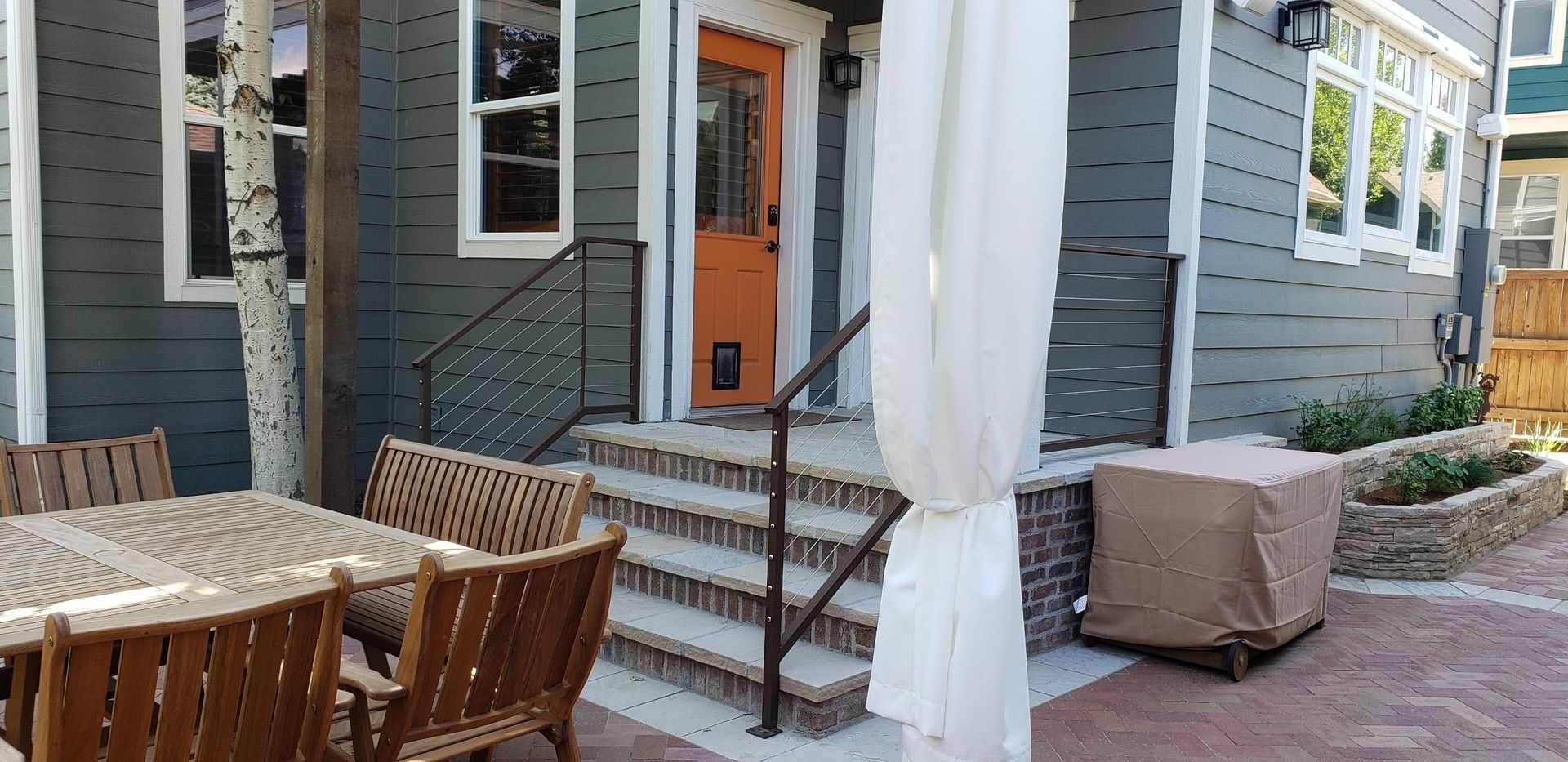 A patio area with a table and chairs in front of a house.