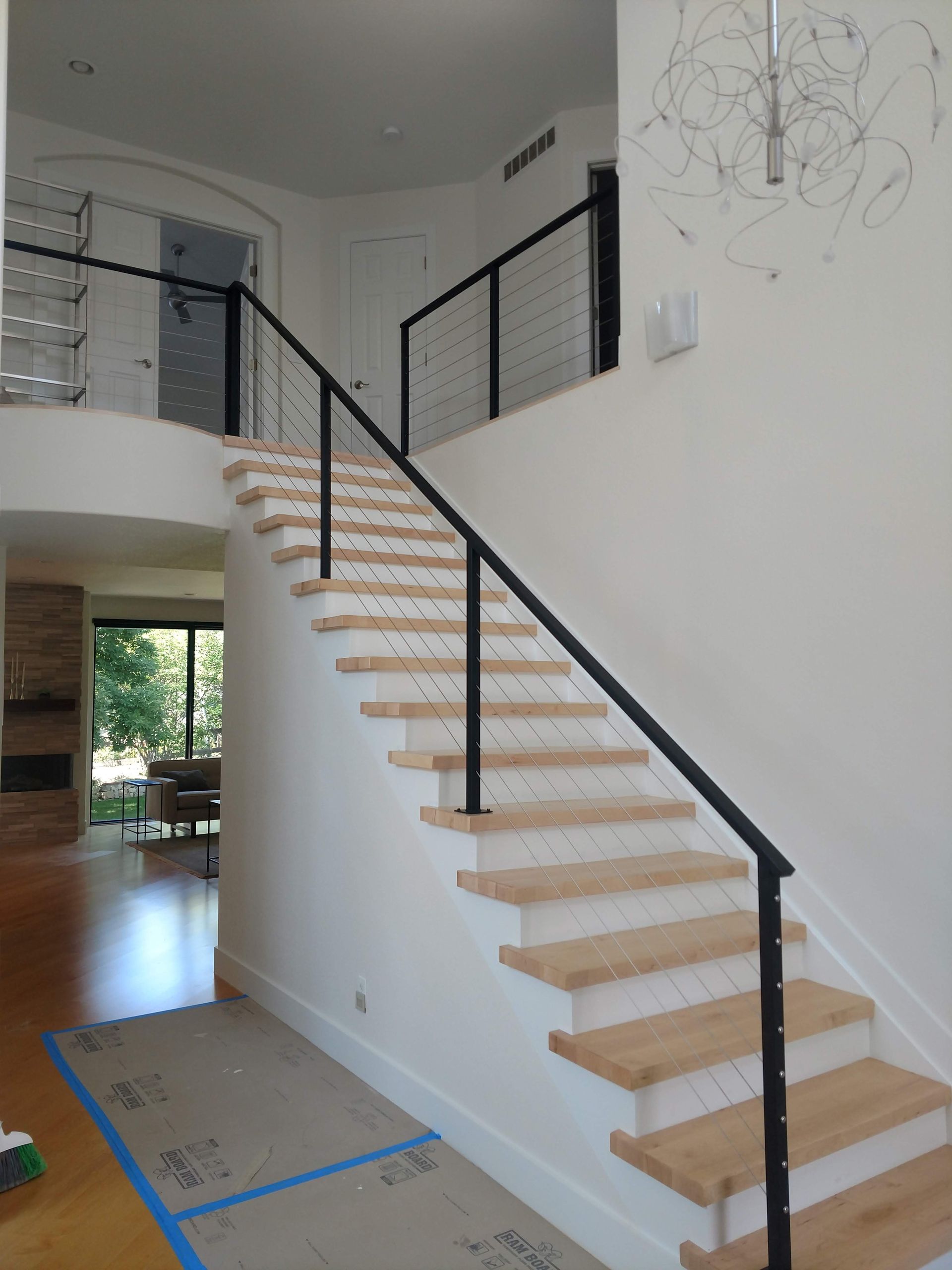 A staircase with wooden steps and a black railing