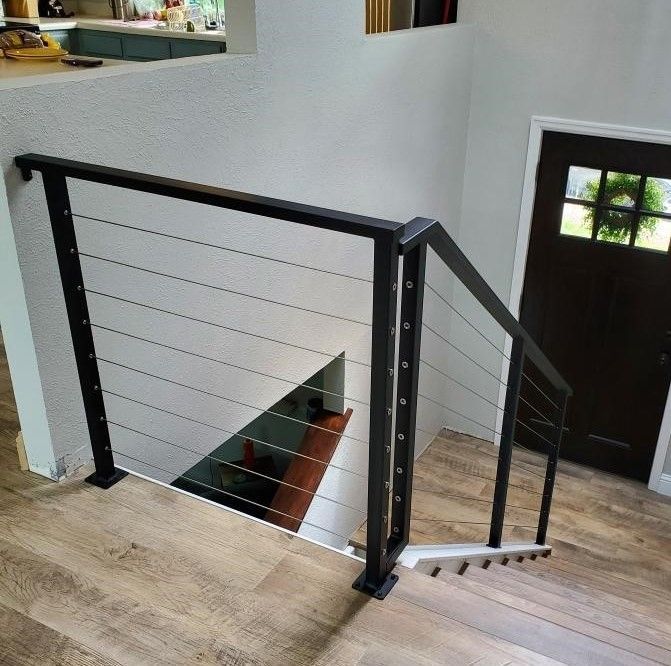 A staircase with a black railing and a wooden floor