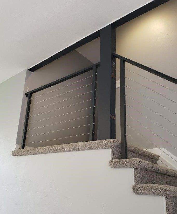 A staircase with a black railing and carpeted steps