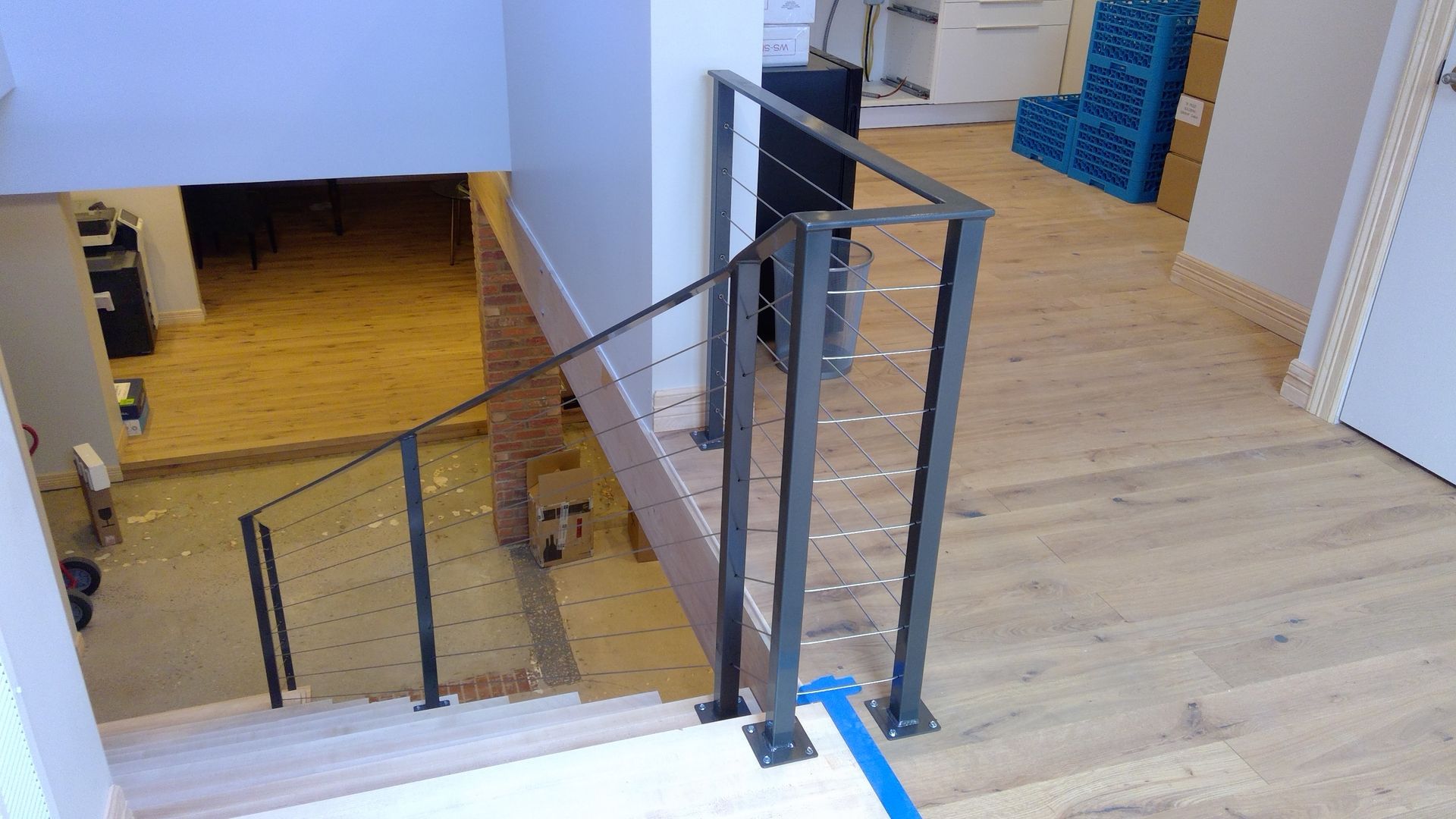 A staircase with a metal railing and a wooden floor in a house.