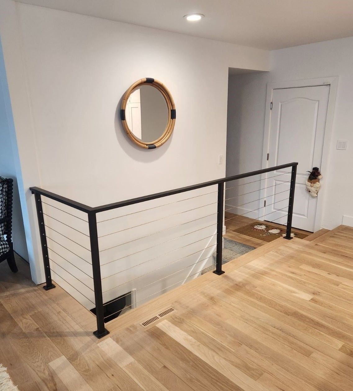 There is a mirror on the wall above the stairs.