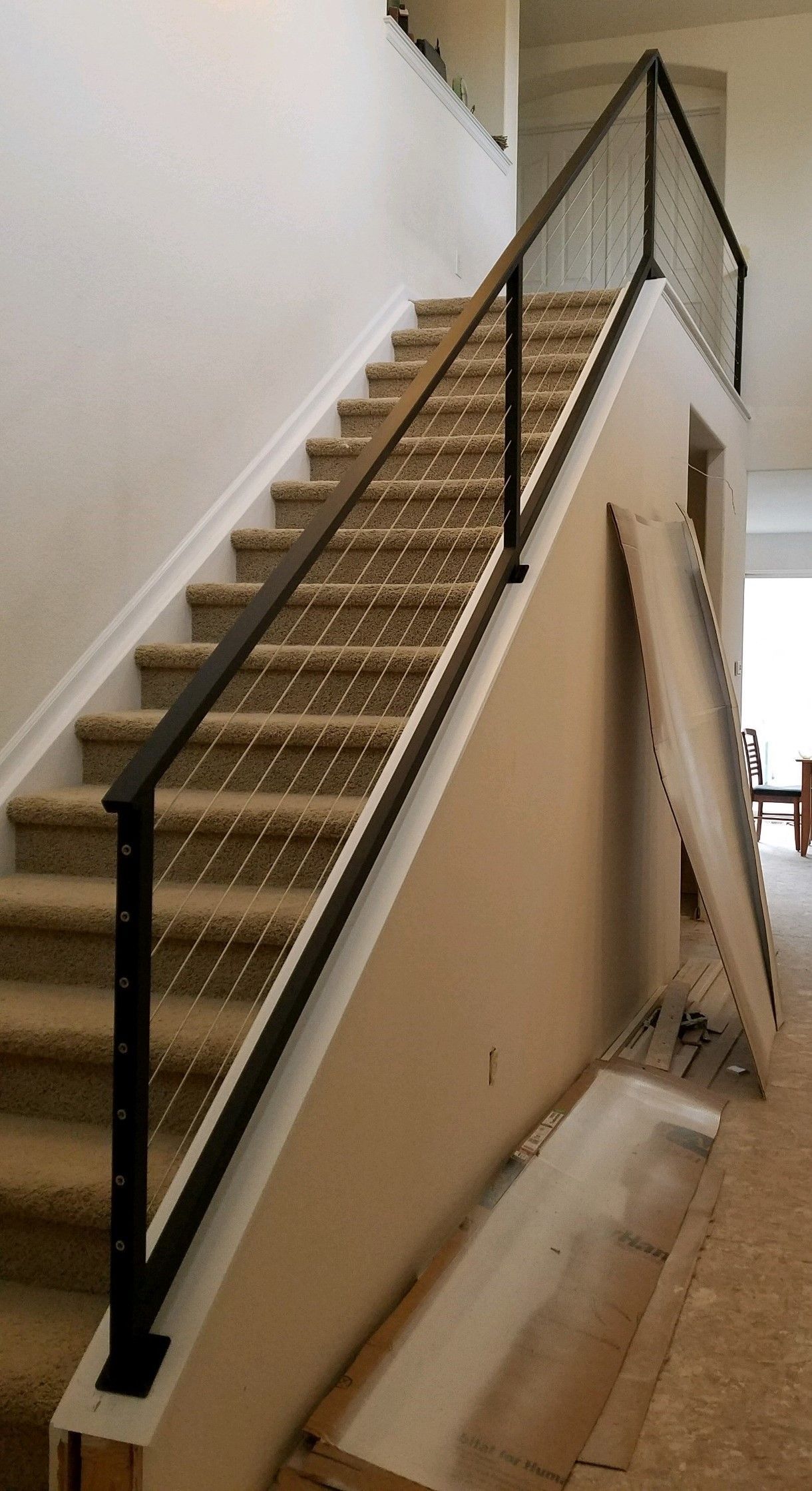 A staircase with a black railing and carpeted steps in a house.