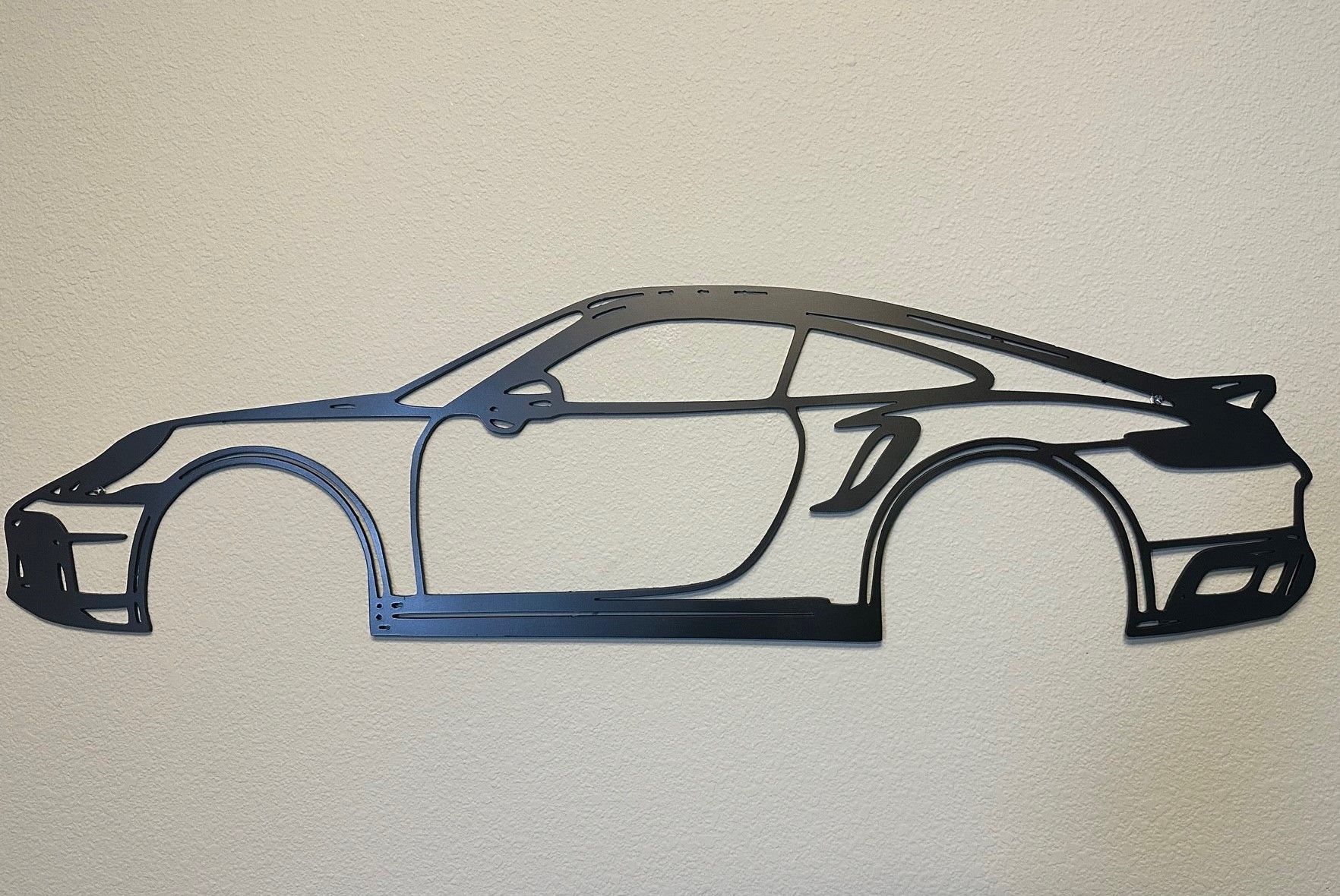 A black and white drawing of a car on a wall