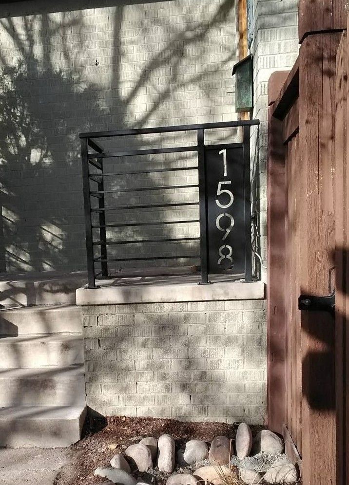 A brick building with a metal railing and a sign that says 1255