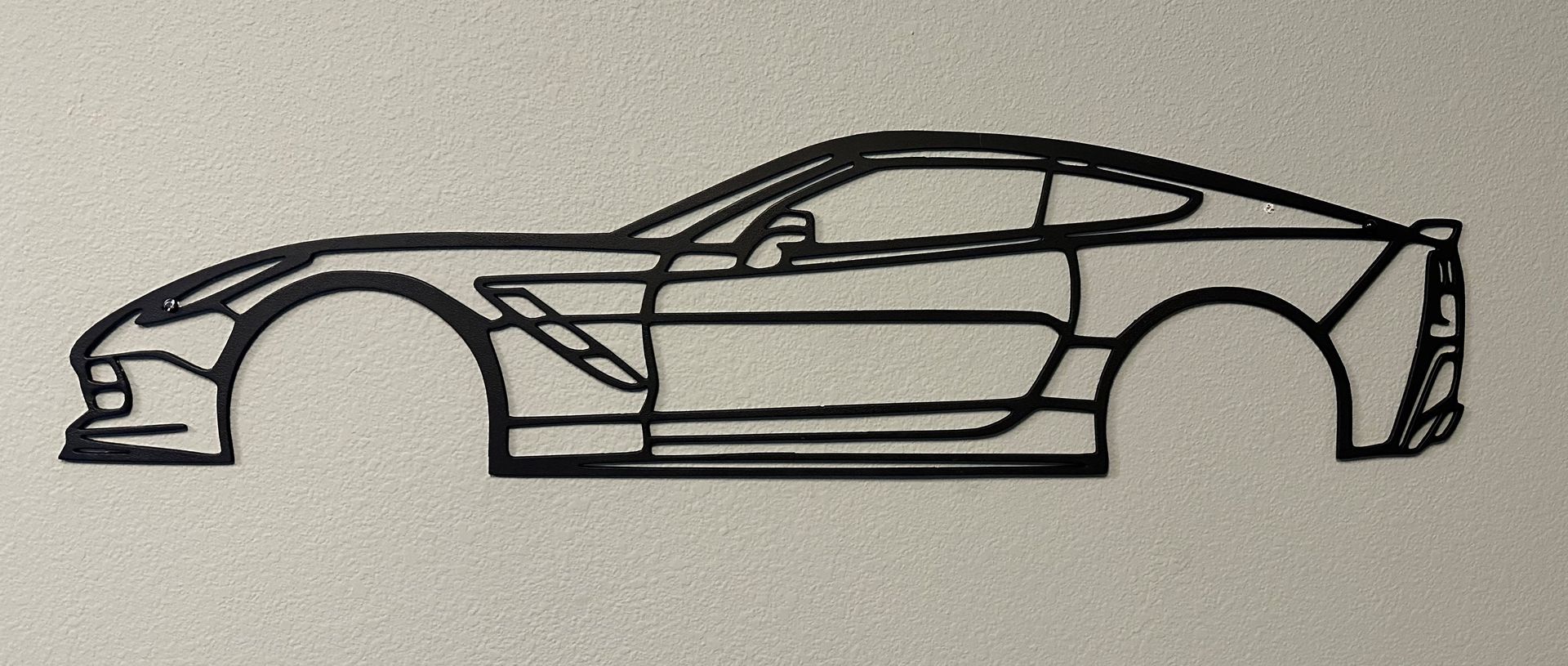 A black and white drawing of a sports car on a white surface.