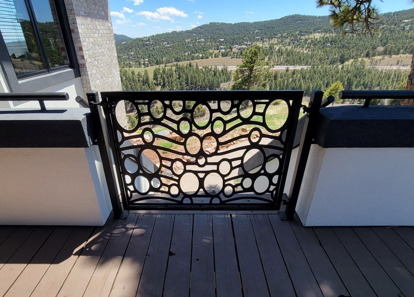 A deck with a fence and a view of the mountains.