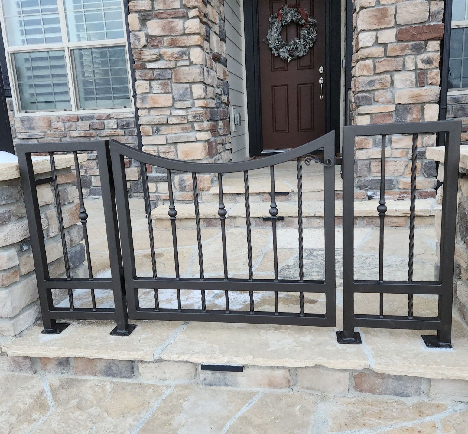 A wooden staircase with a metal railing and white carpet