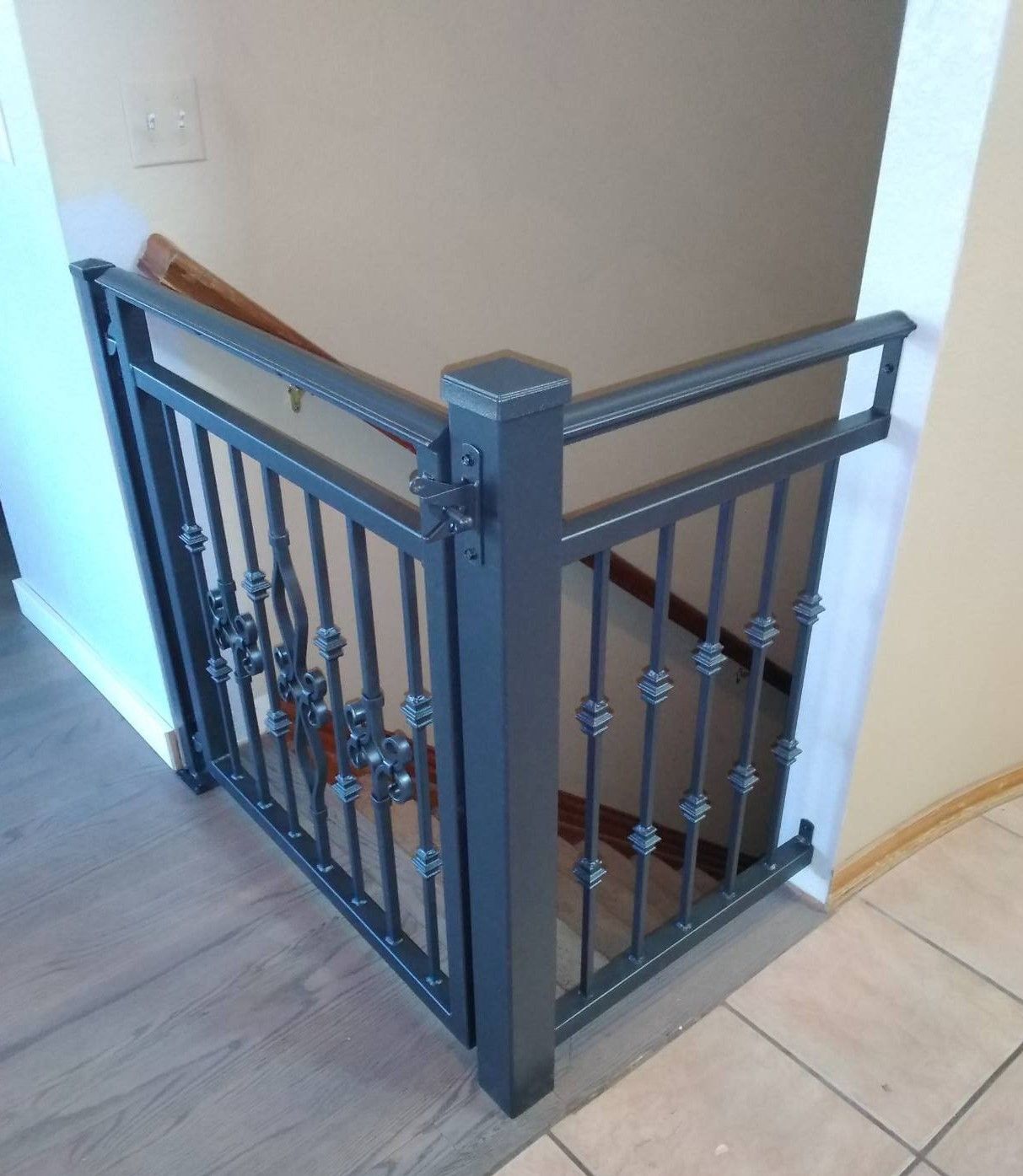 A staircase with a black railing and a wooden handrail