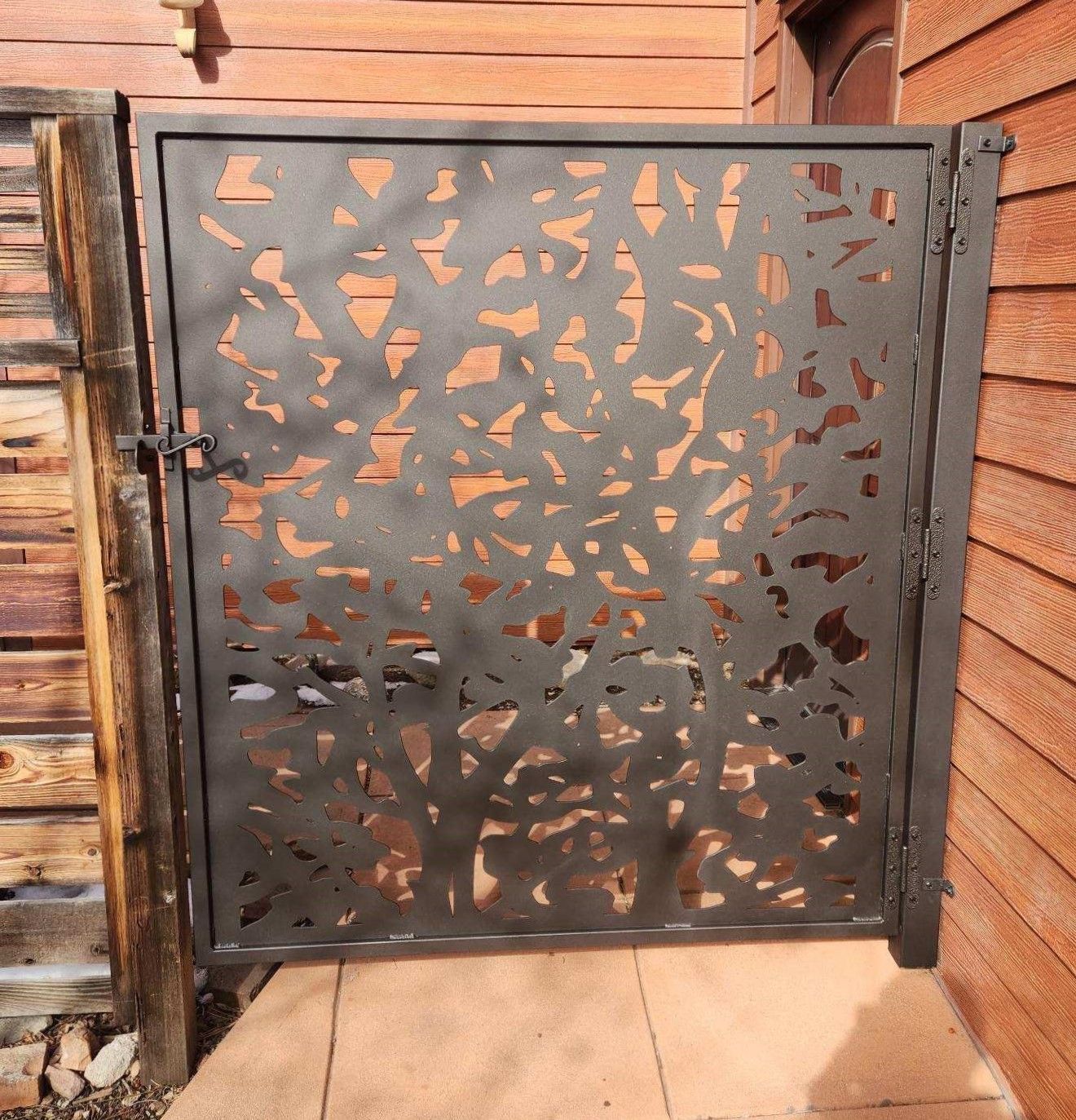 A metal gate with a wooden fence in the background