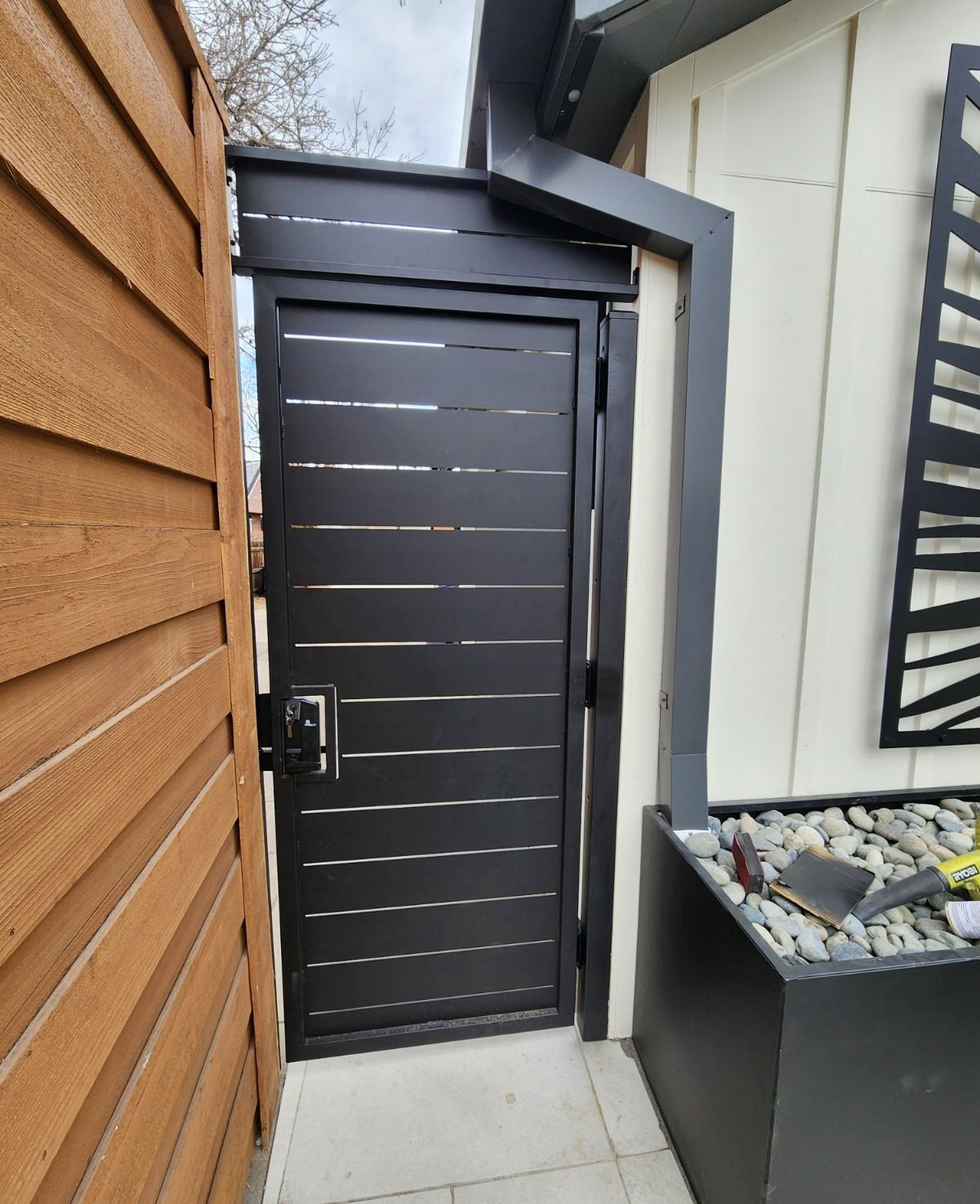 A black door is between two wooden fences