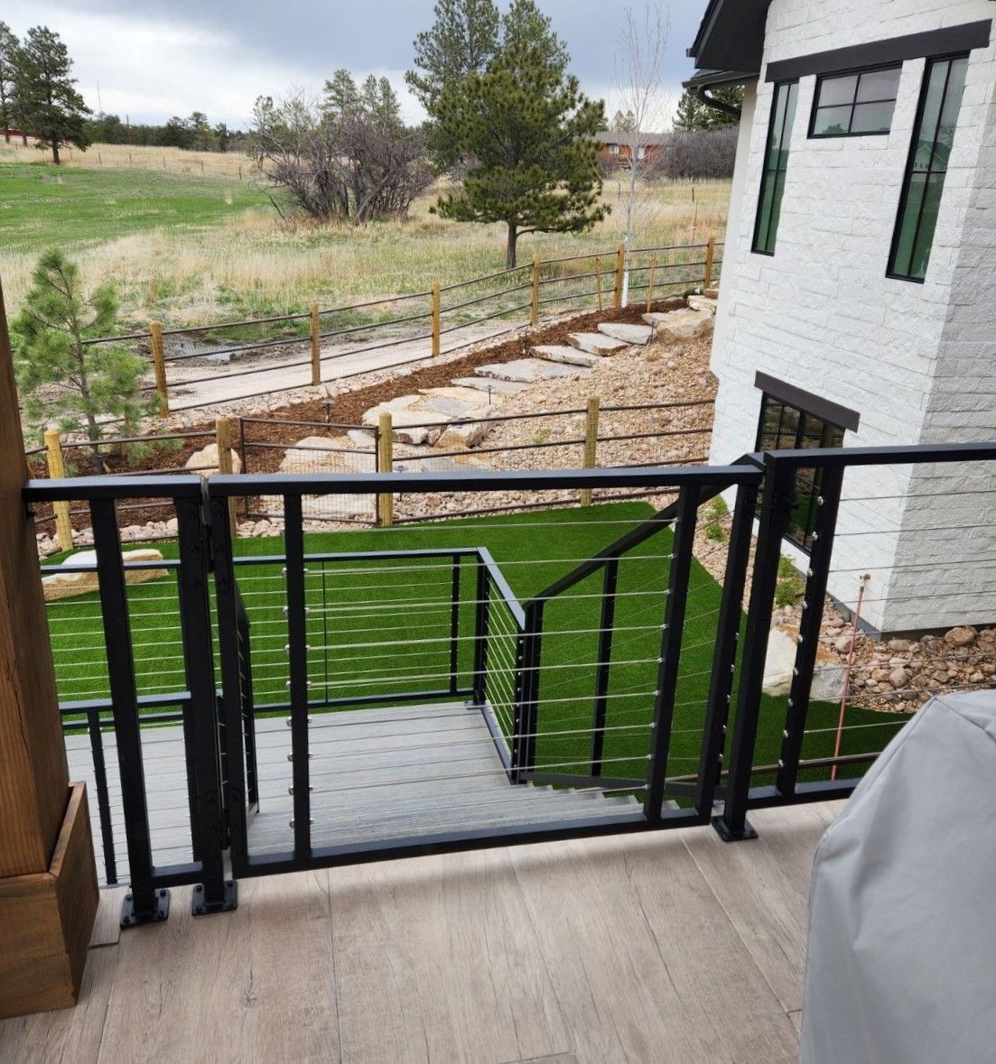 Stairs leading up to a house with a black railing