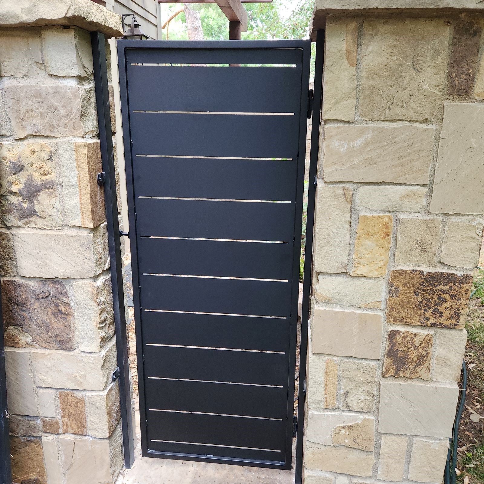 A black gate is between two stone pillars