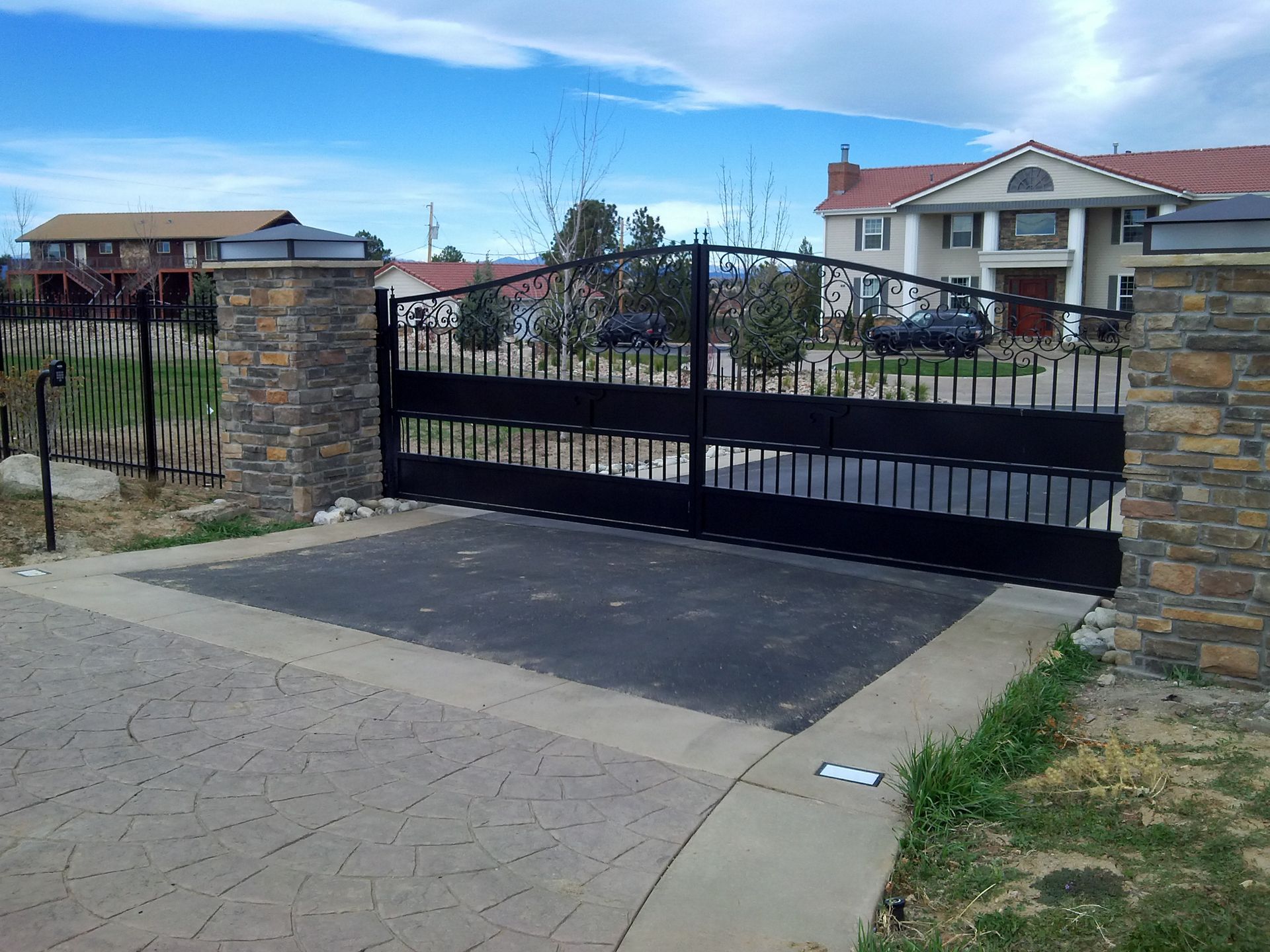A black gate is open in front of a house
