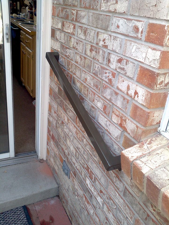 A brick wall with a hand rail on it