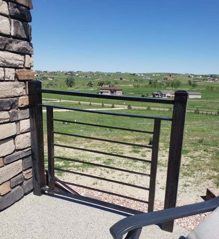 A chair is sitting on a balcony overlooking a field.