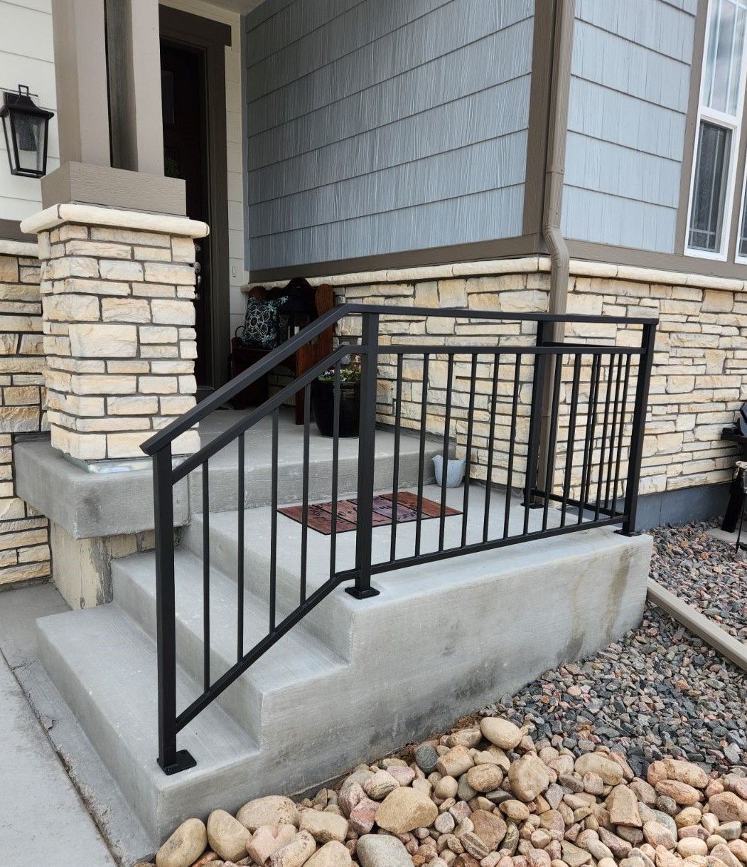 A front porch with stairs and a black railing