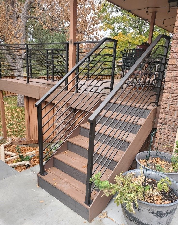 A set of stairs leading up to a deck with a metal railing.
