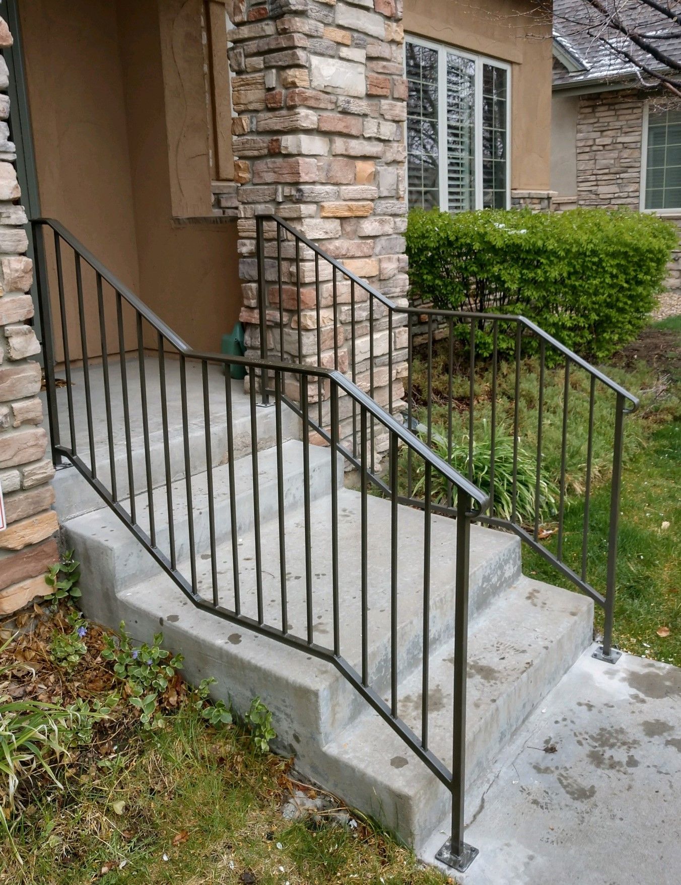 There is a wrought iron railing on the steps of a house.
