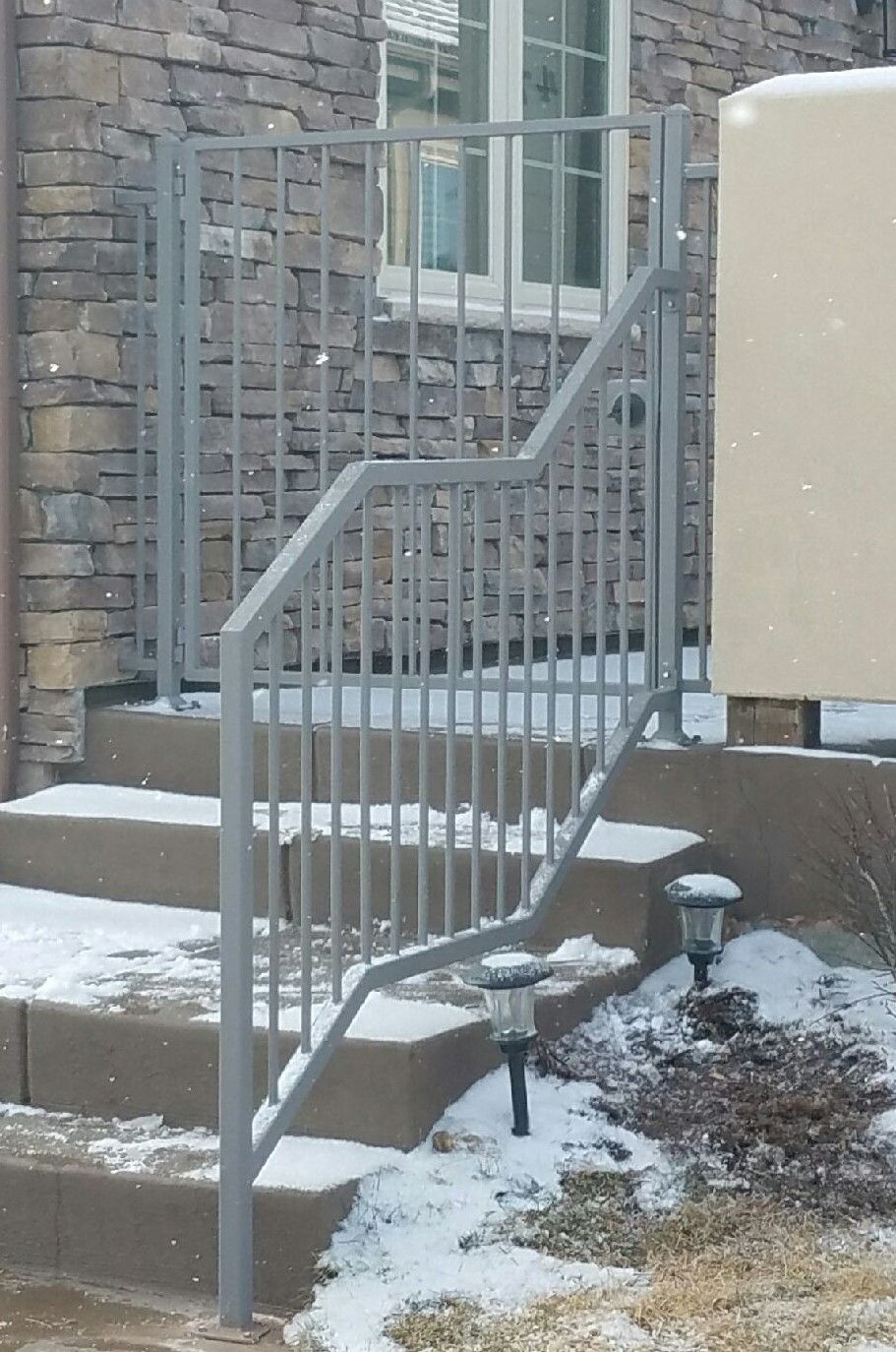 A staircase with snow on the steps and a metal railing