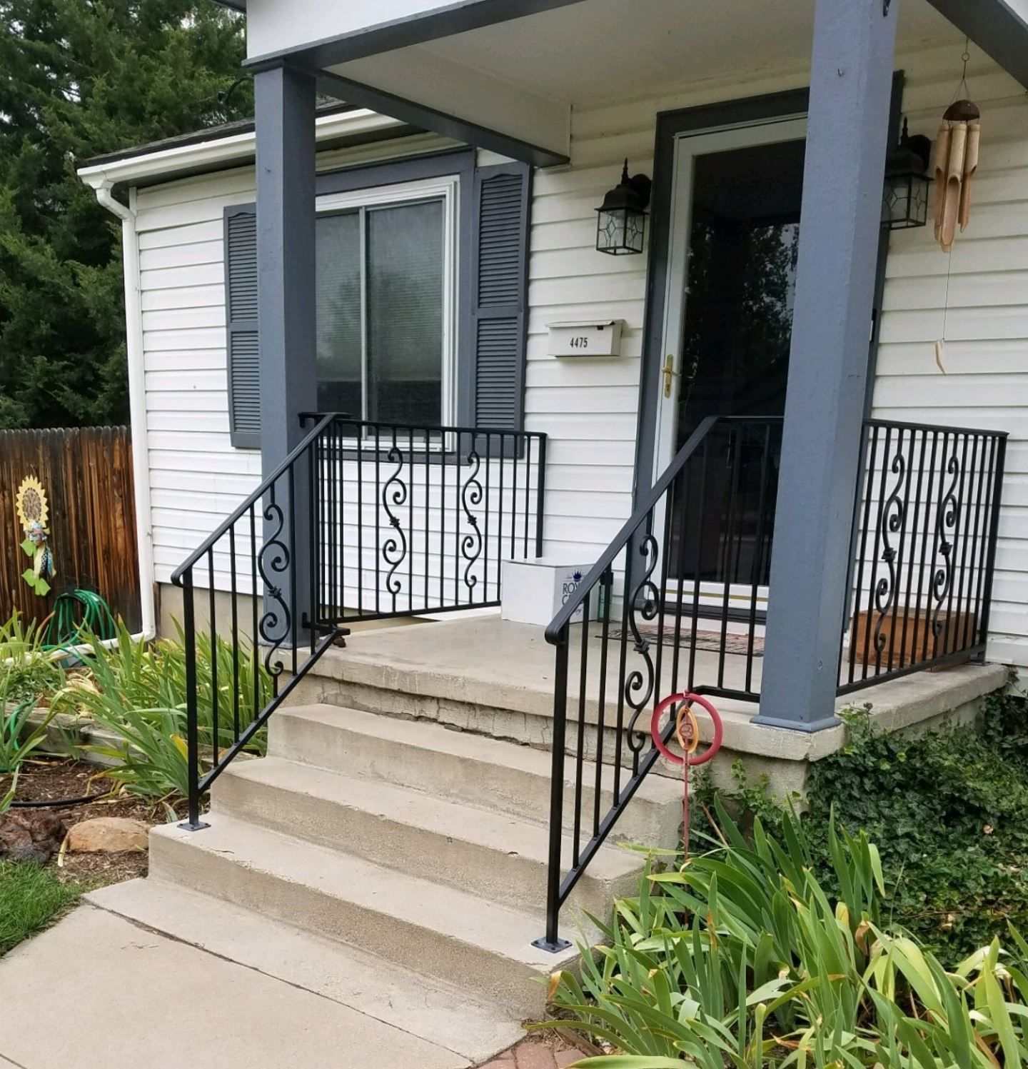 A white house with a black railing and stairs