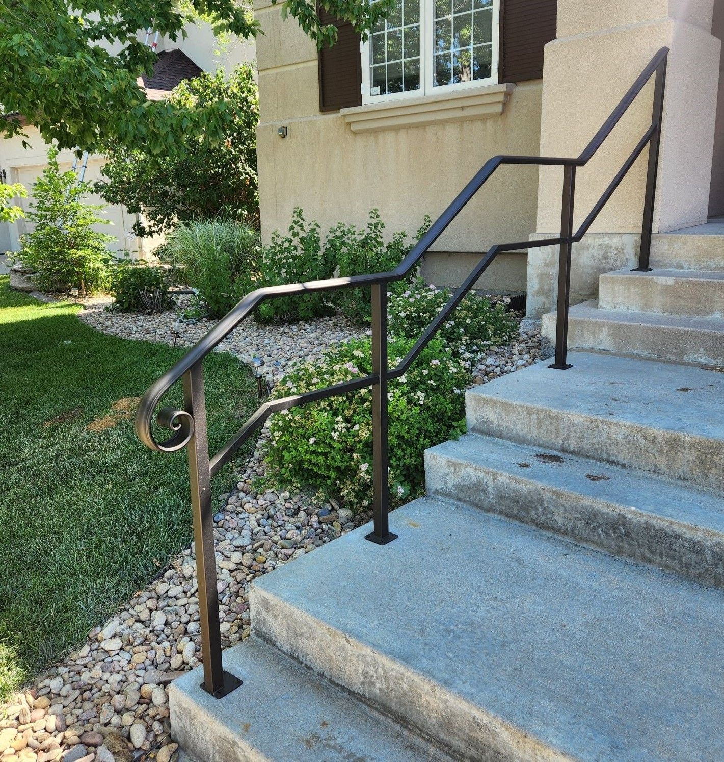 A set of stairs with a metal railing leading up to a house