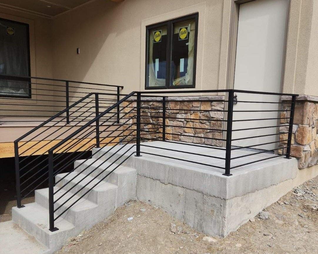 A staircase with a metal railing on the side of a house.