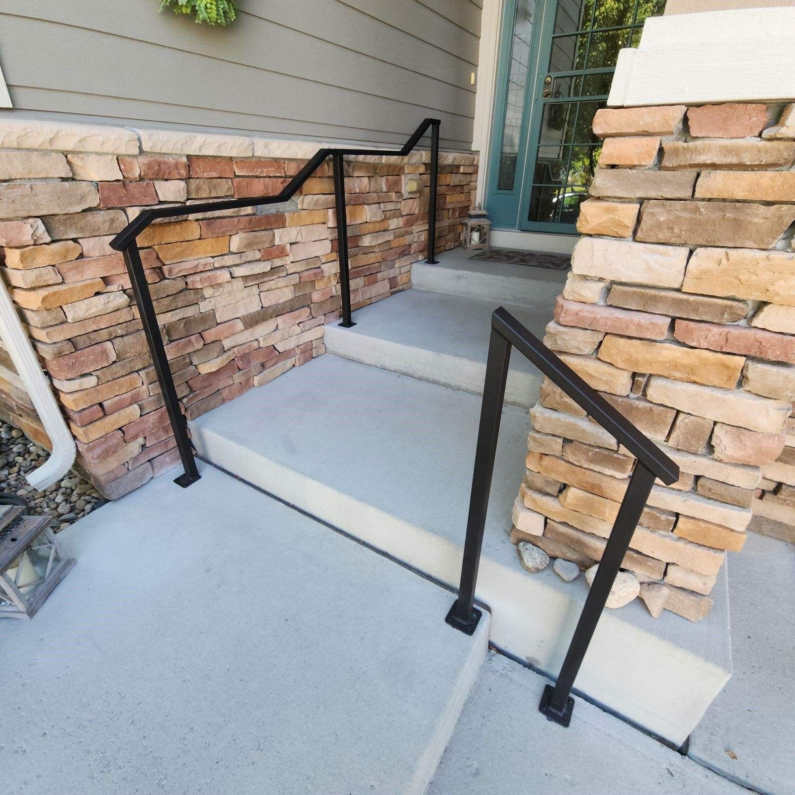 A brick wall with stairs and a black railing