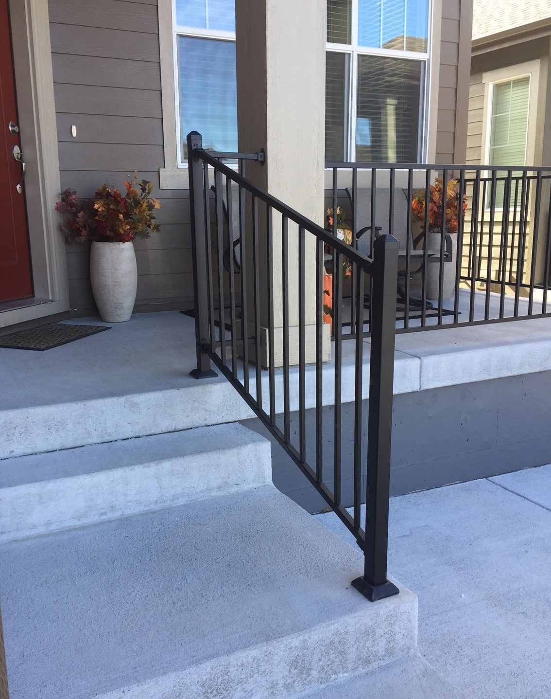 A porch with stairs and a metal railing