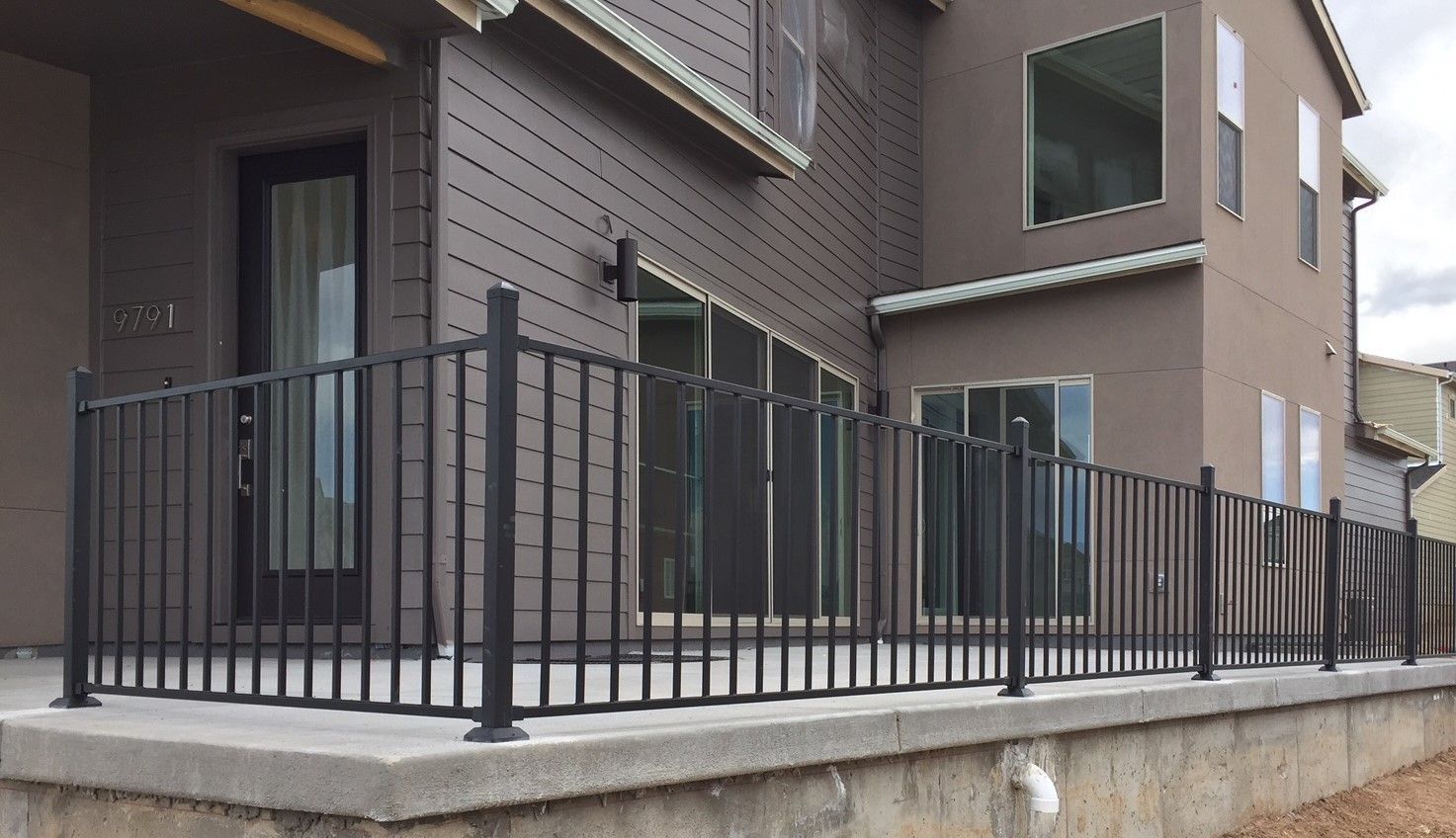 A house with a fence around it and a balcony.