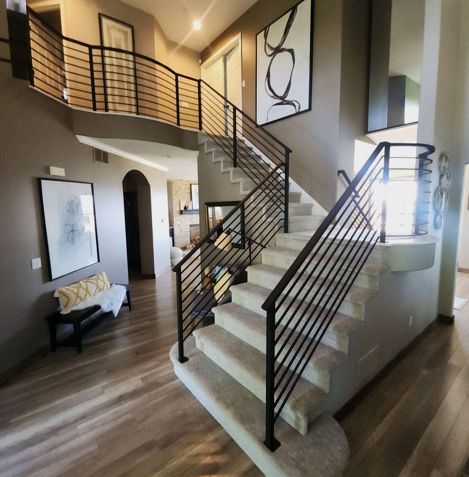 A staircase in a house with a black railing