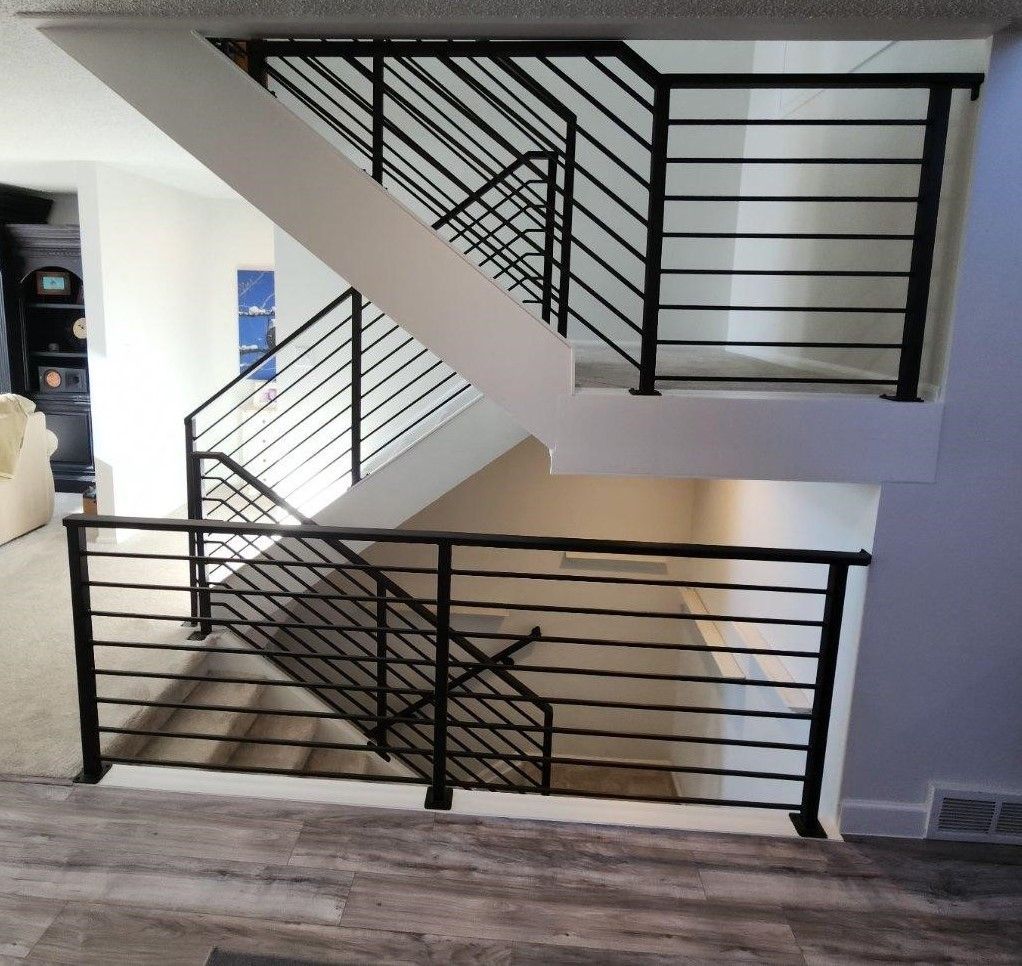 A staircase with a black railing in a house
