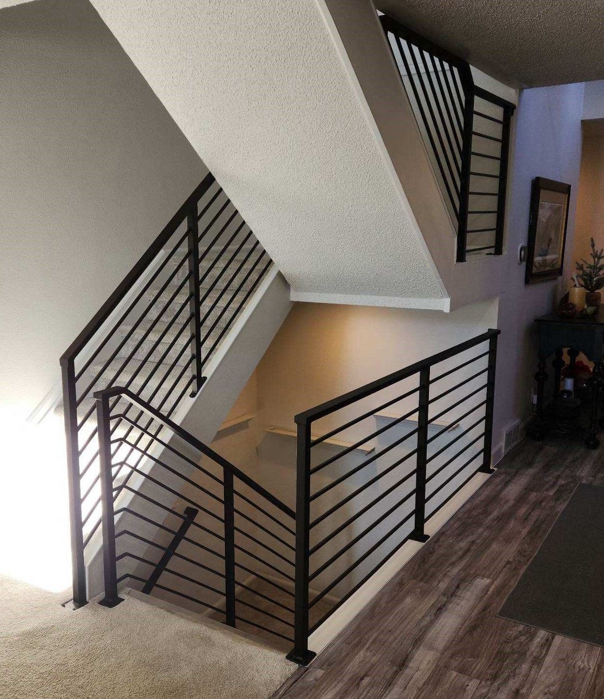 A staircase with a black railing in a living room.