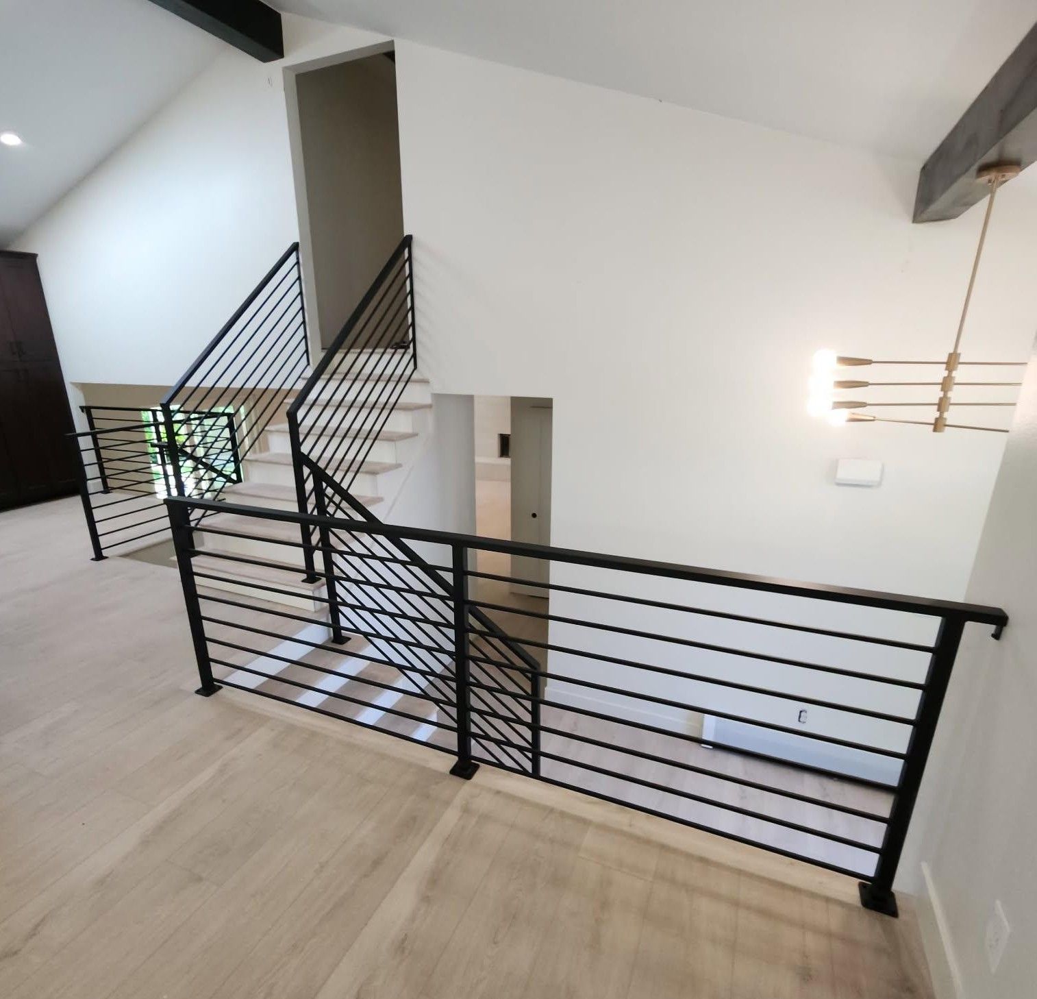 A staircase in a house with a black railing