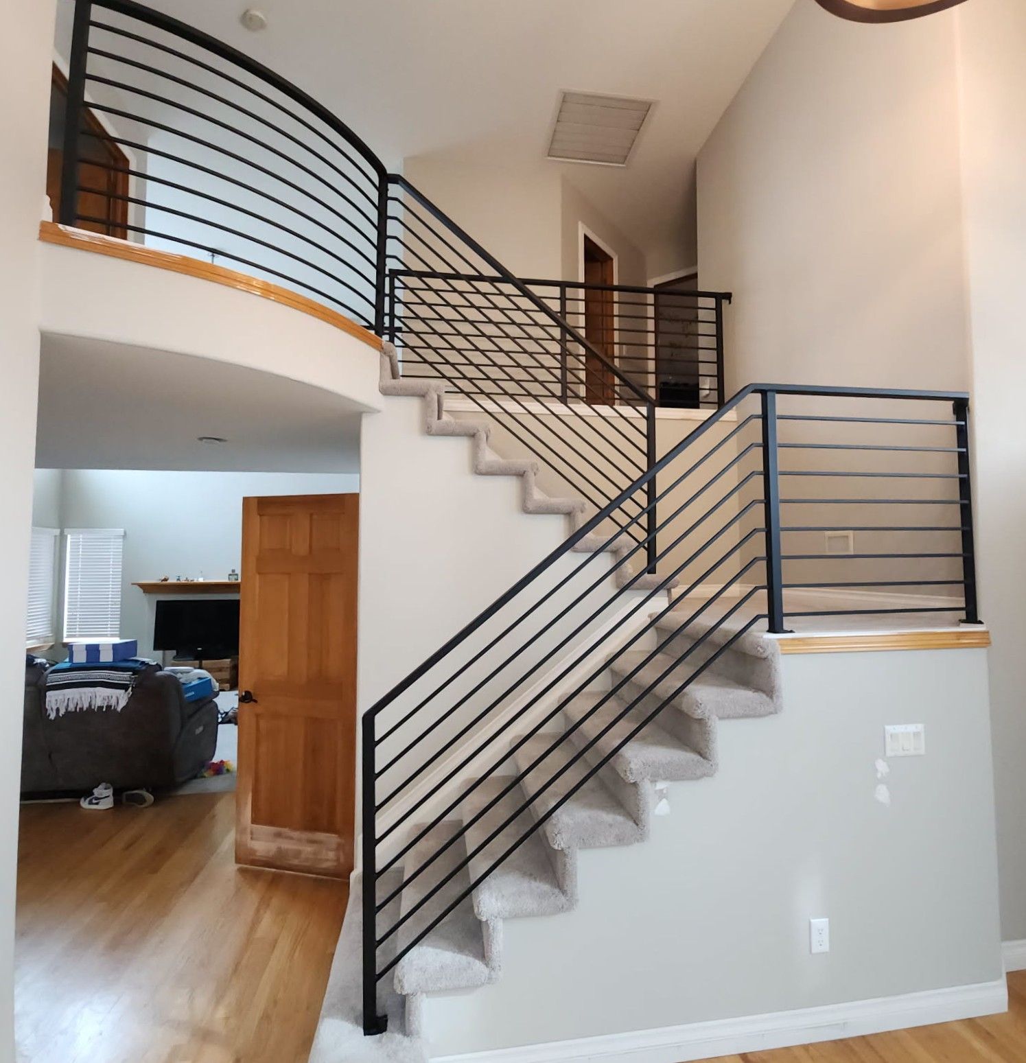 A staircase in a house with a black railing