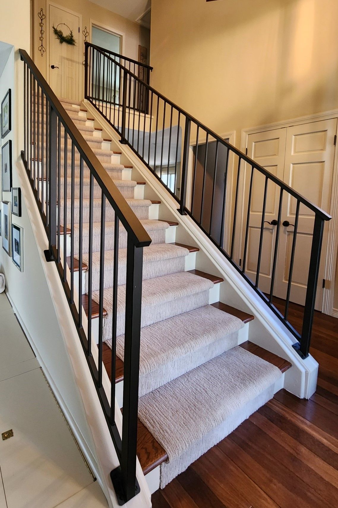 A staircase with a black railing and carpeted steps