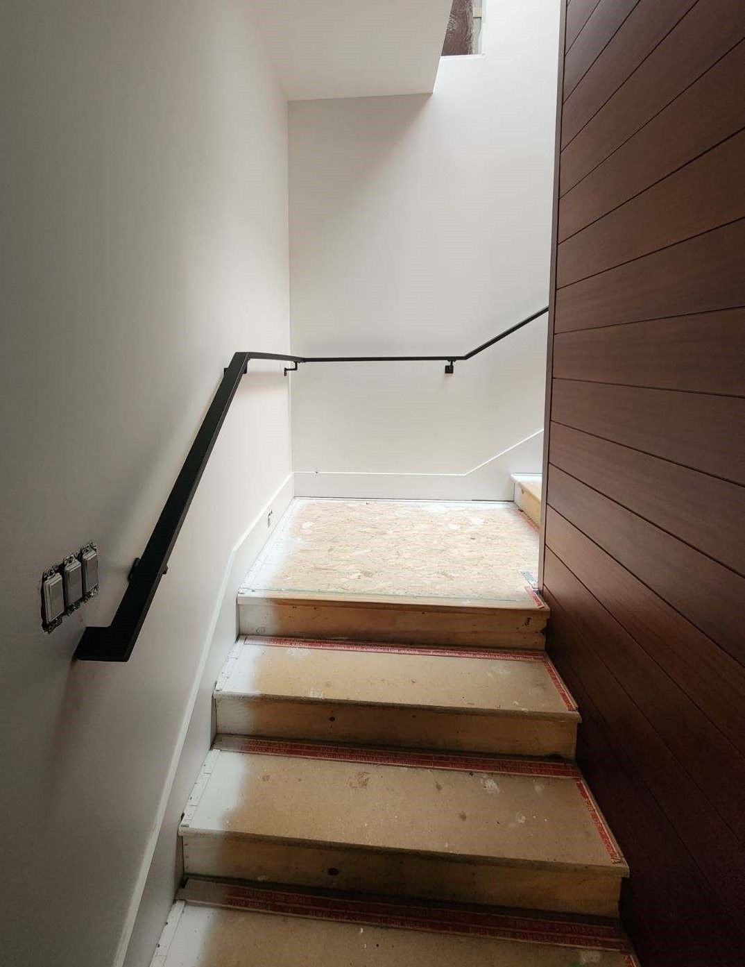 A set of stairs leading up to a ceiling with a railing.