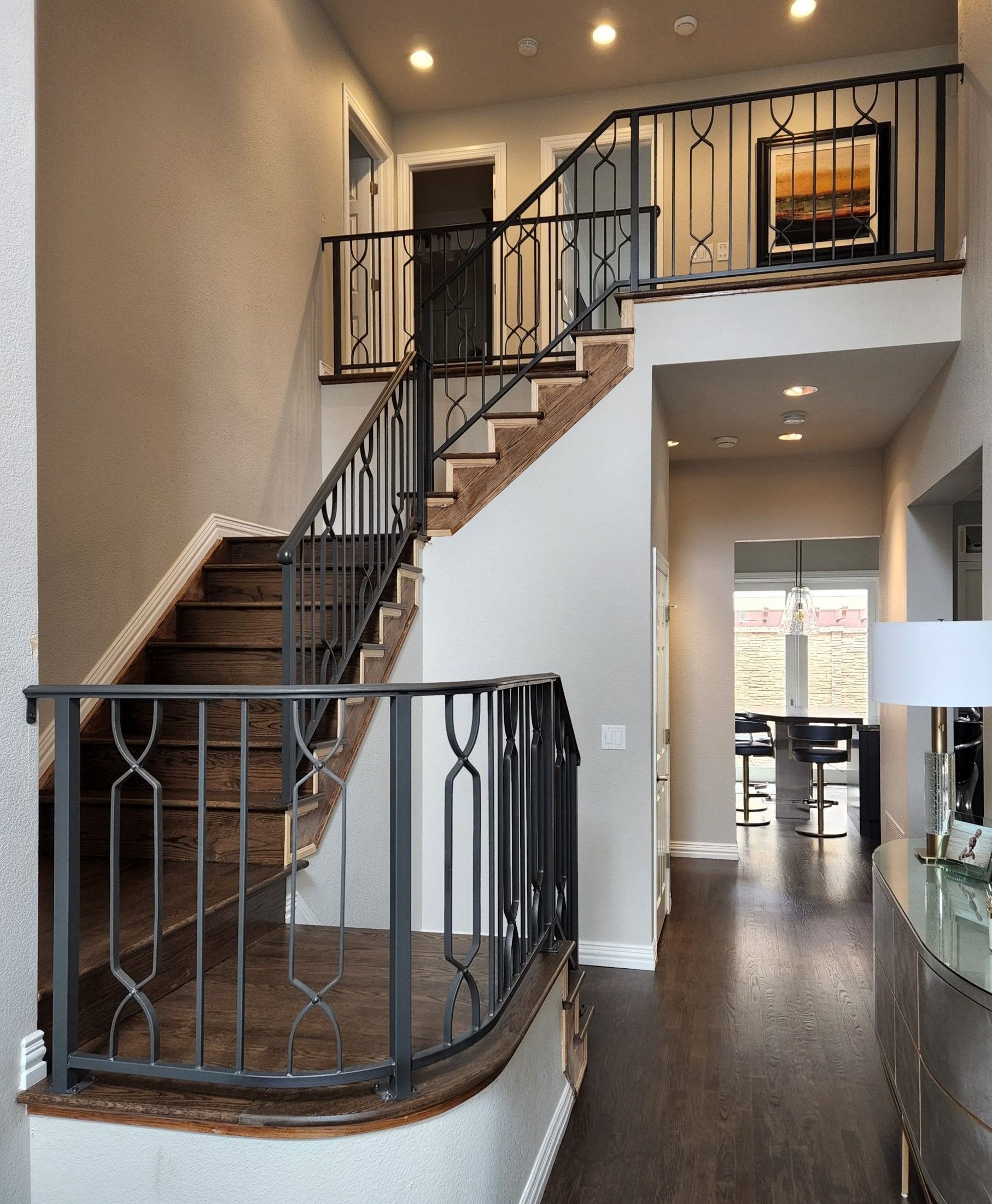 A staircase in a house with a wrought iron railing