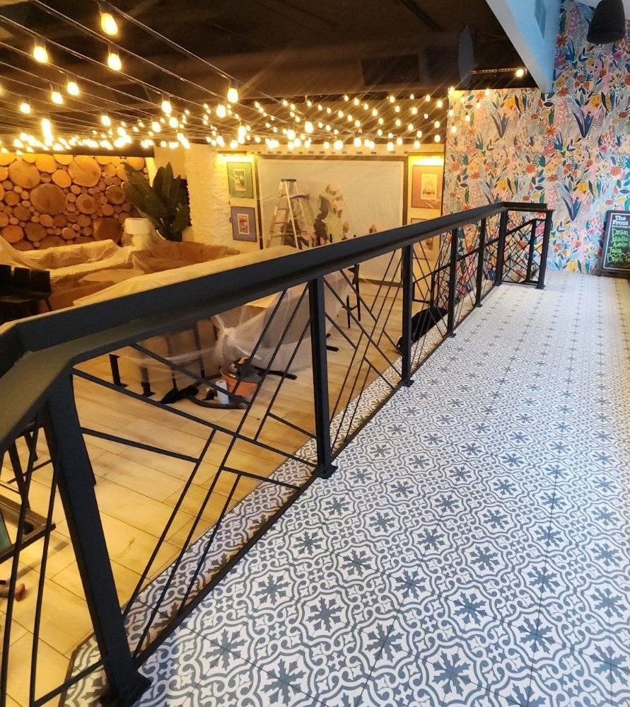 A hallway with a railing and a patterned floor