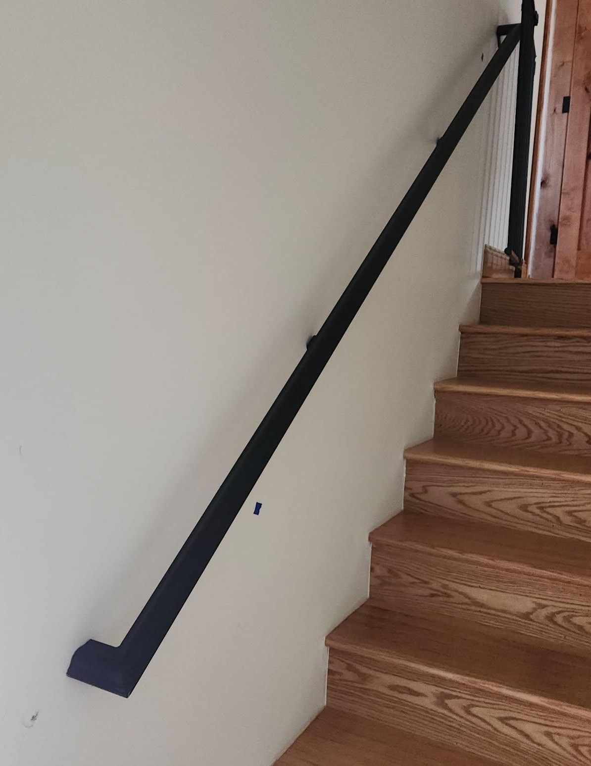 A staircase with a black railing and wooden steps.