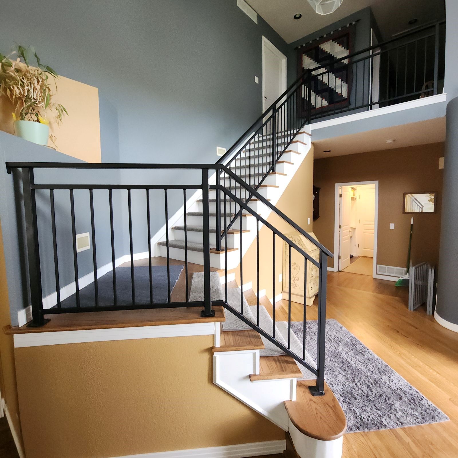 A staircase in a house with a black railing
