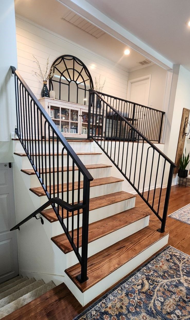 A wooden staircase with a metal railing in a living room.
