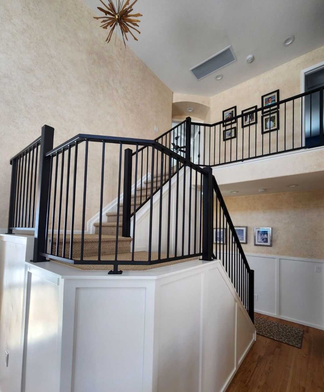 A staircase with a black railing leading up to the second floor