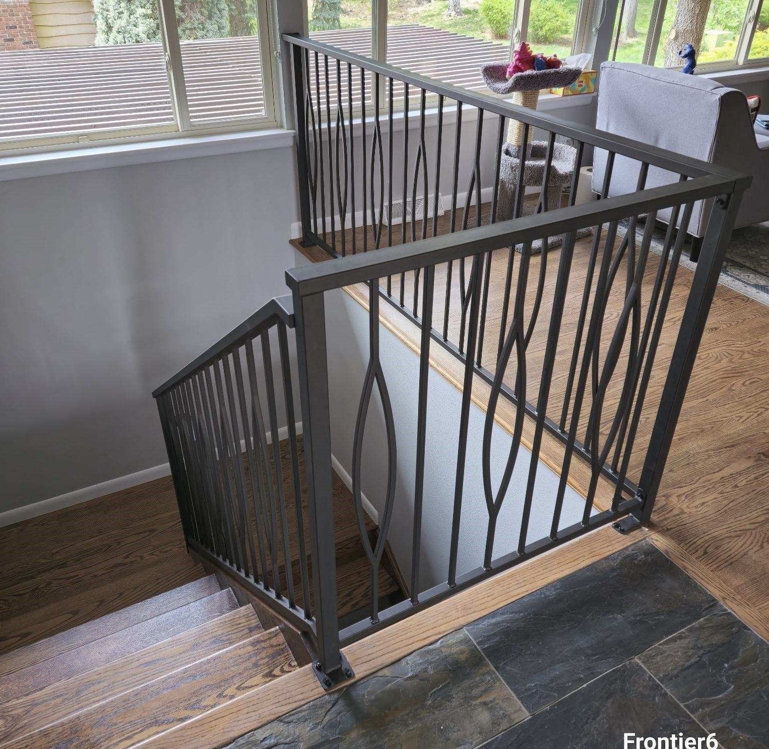 A staircase with a metal railing and wooden steps in a house.