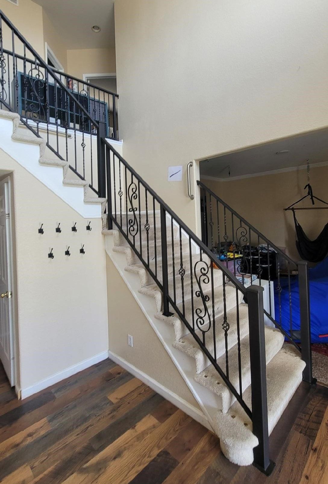 A staircase with a wrought iron railing leading up to the second floor of a house.