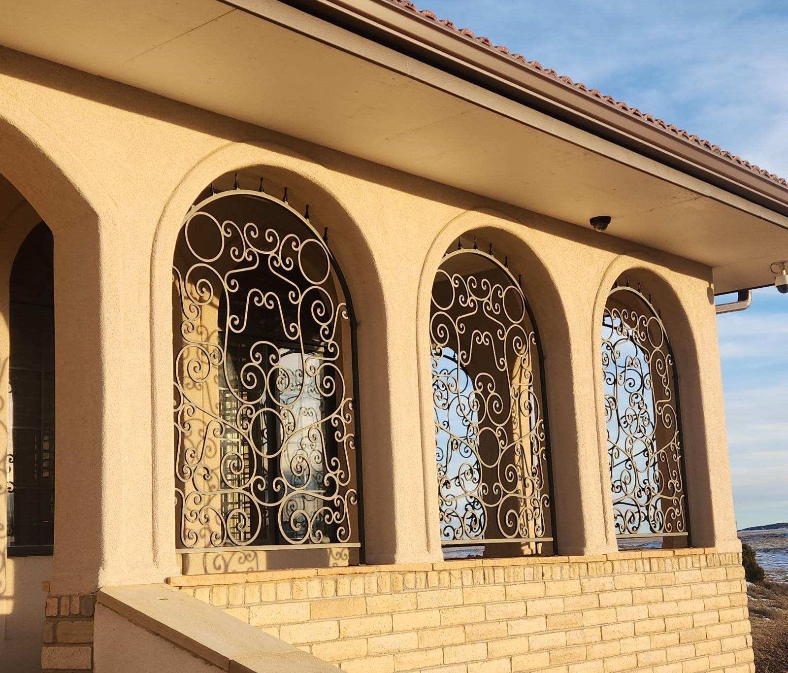 A brick building with arched windows and wrought iron fences
